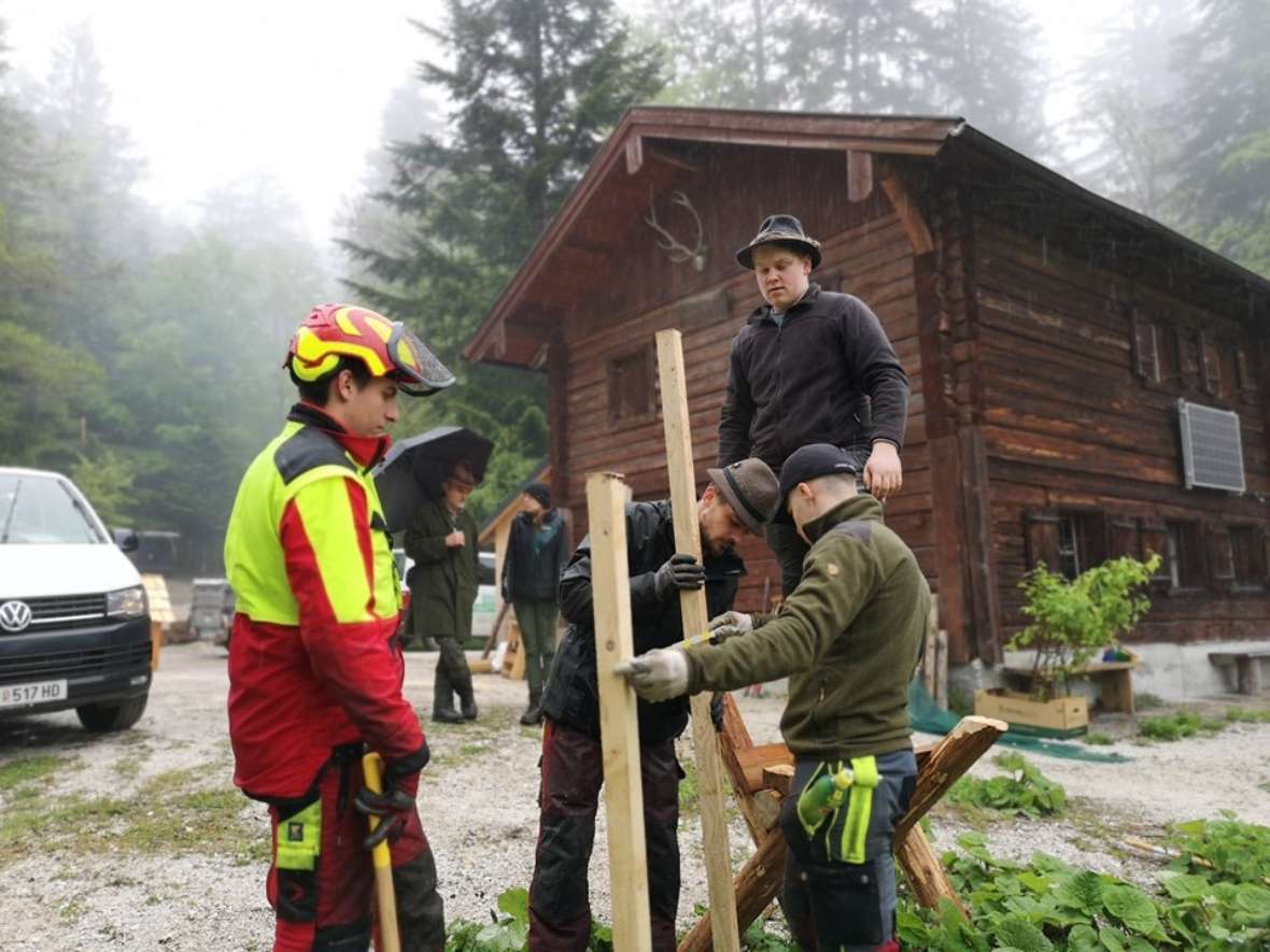 Schüler arbeiten in Jagd- und Forstkleidung mit Holz